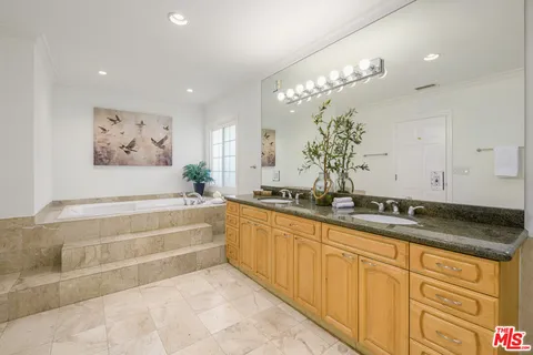 an empty room with wooden floor chandelier and windows