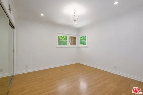 a view of empty room with wooden floor and window