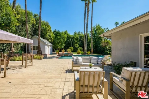 a view of a swimming pool with a patio and a yard