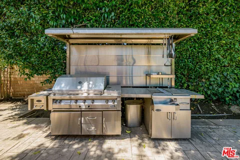 a view of a house with pool lawn chairs under an umbrella