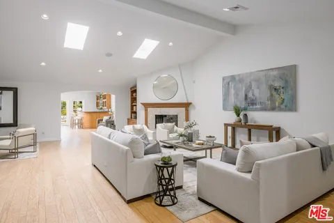 a living room with furniture a fireplace and a potted plant