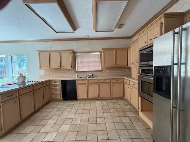 a large kitchen with a stove top oven cabinets a sink and a refrigerator