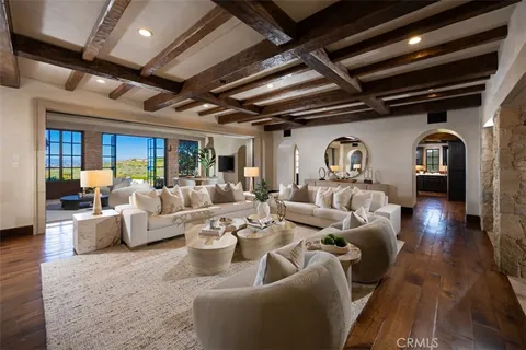 a view of a living room filled with furniture and floor to ceiling windows