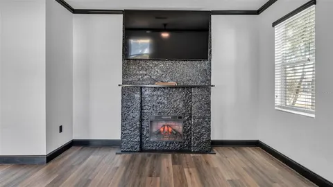 a view of a kitchen with stainless steel appliances granite countertop a stove refrigerator and a large window with wooden floor