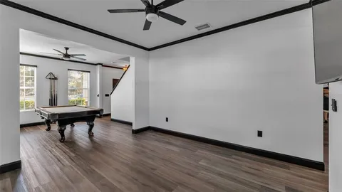 a room with pool table and windows