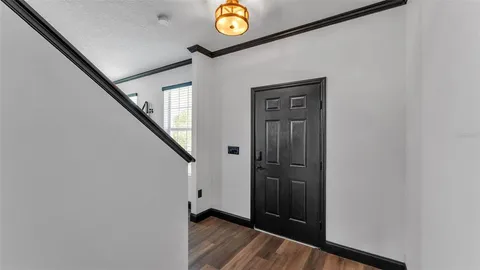 a view of a hallway with wooden floor and stairs