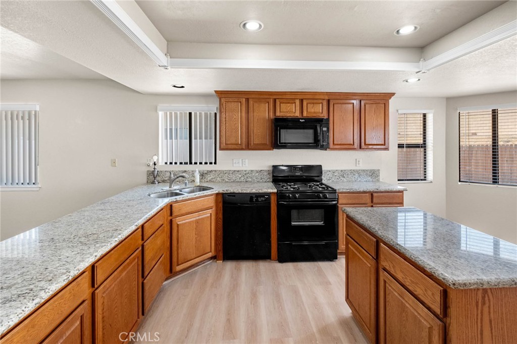 13904 Hidden Valley Road Victorville, CA 92395 - Photo 12 of 47 a kitchen with stainless steel appliances granite countertop a stove a sink and a granite counter tops
