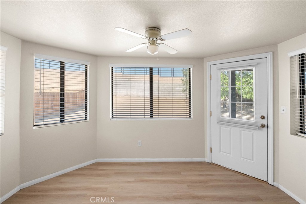 13904 Hidden Valley Road Victorville, CA 92395 - Photo 15 of 47 a view of an empty room with wooden floor and a window