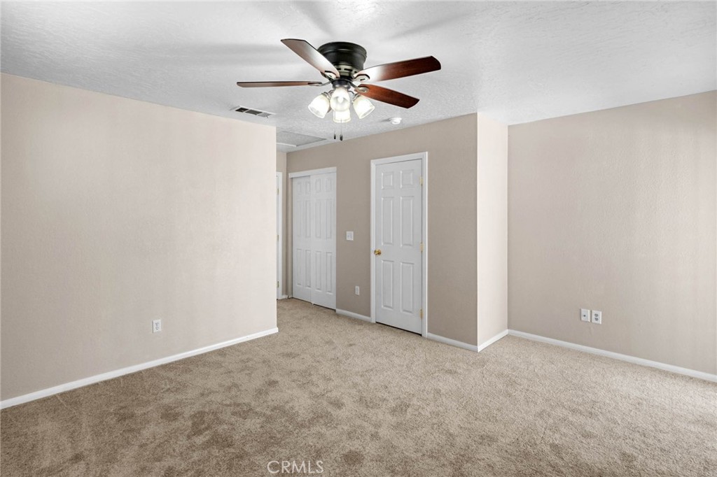 13904 Hidden Valley Road Victorville, CA 92395 - Photo 23 of 47 an empty room with ceiling fan and window