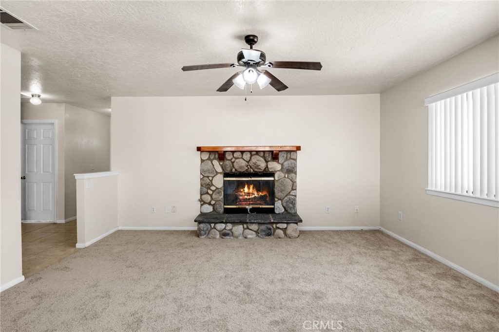 13904 Hidden Valley Road Victorville, CA 92395 - Photo 5 of 47 an empty room with a ceiling fan and window
