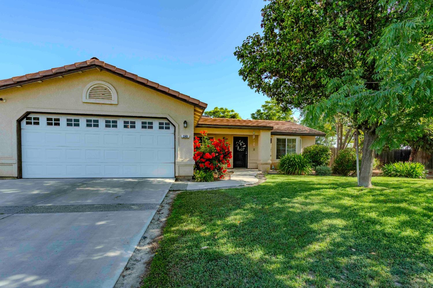 a view of a house with a small yard and a car parked in it
