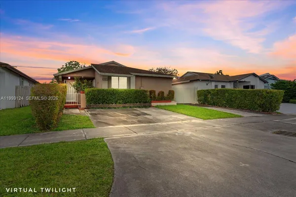 a view of a big house with a big yard and large tree