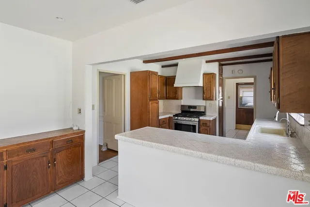a kitchen with stainless steel appliances kitchen island granite countertop a refrigerator and wooden cabinets