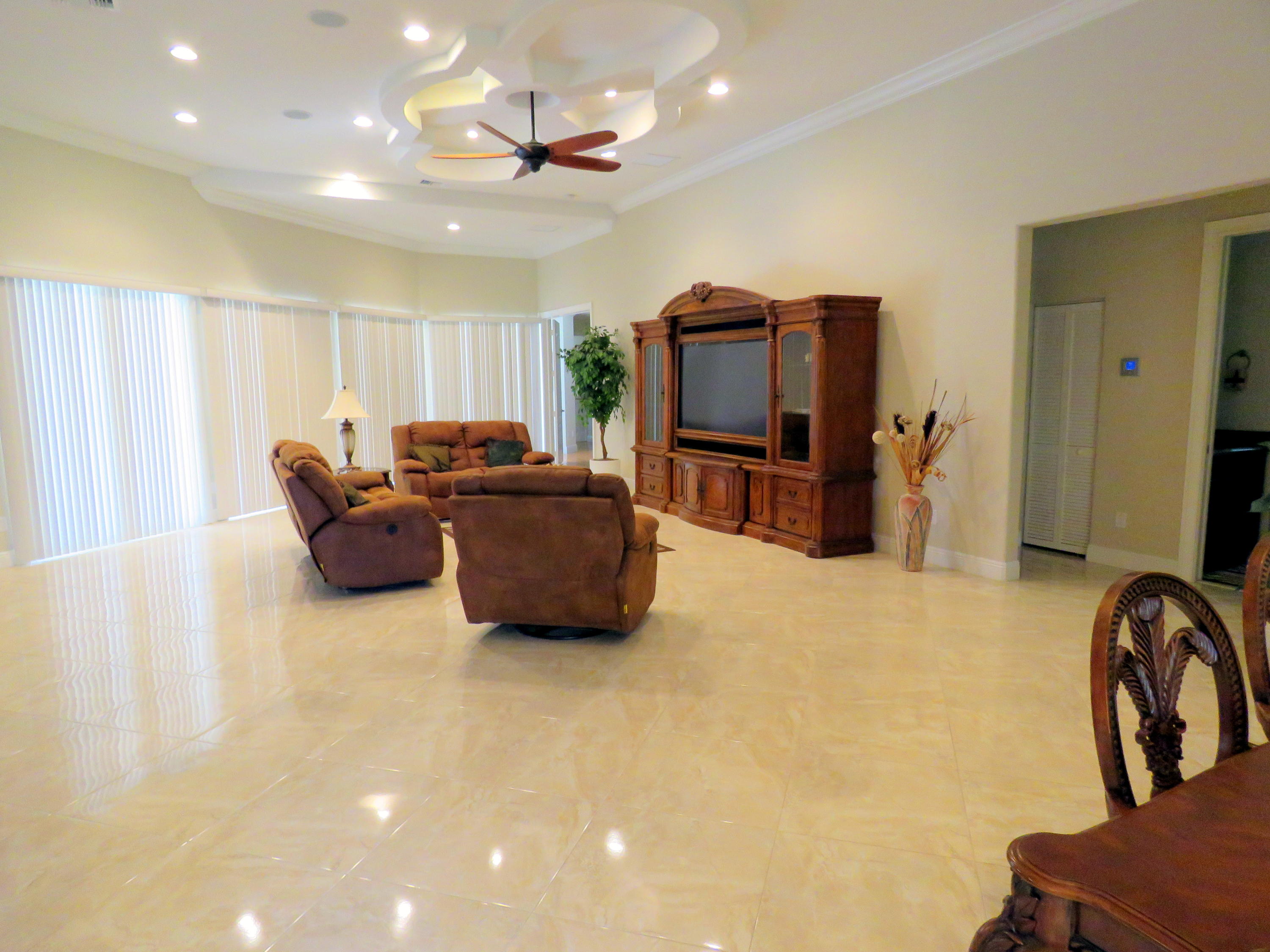 1059 E Road Loxahatchee, FL 33470 - Photo 12 of 82 a living room with furniture a flat screen tv and a refrigerator