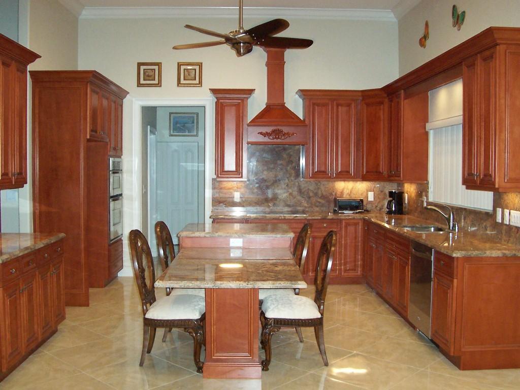 1059 E Road Loxahatchee, FL 33470 - Photo 24 of 82 a kitchen with granite countertop a dining table chairs and a refrigerator