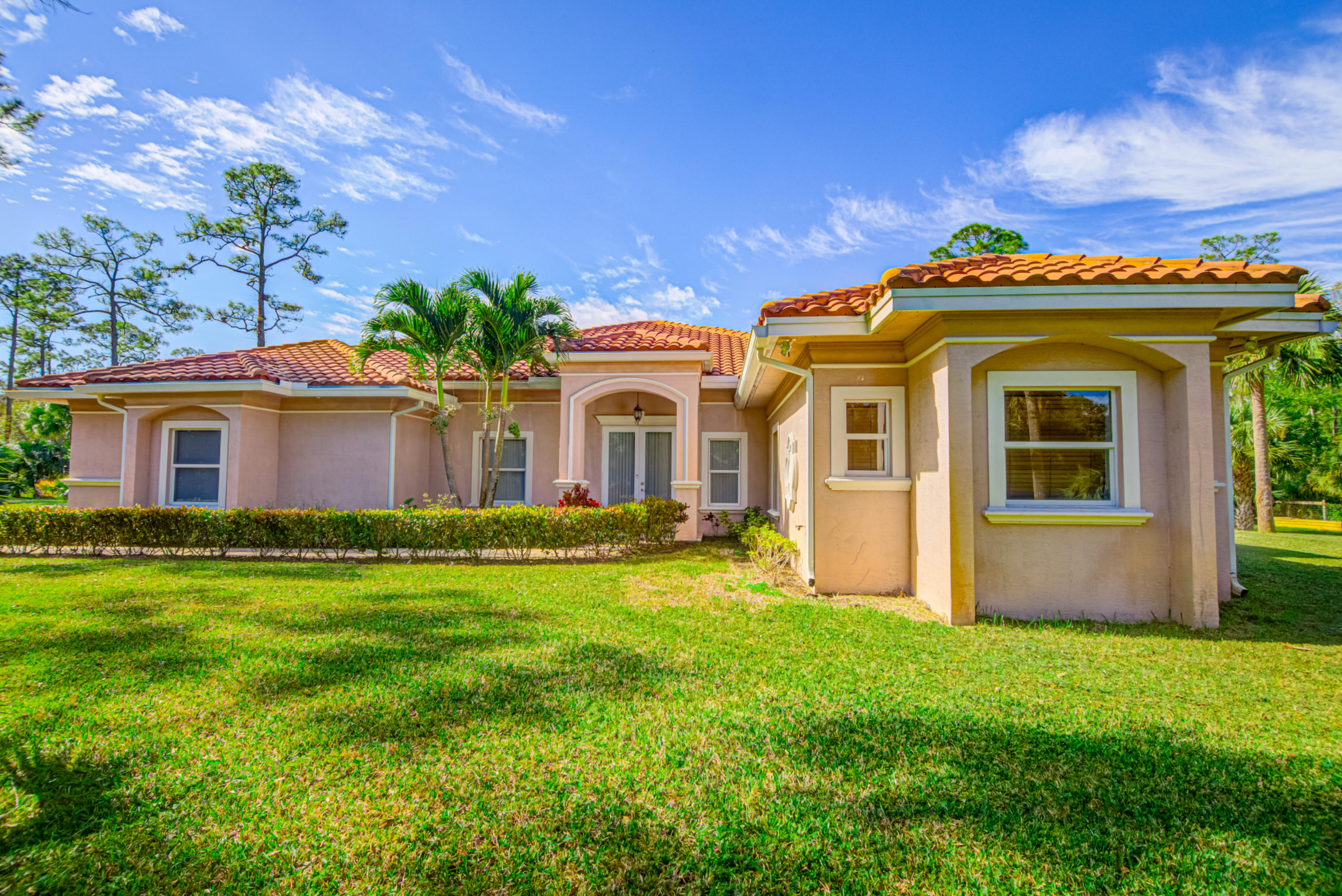 1059 E Road Loxahatchee, FL 33470 - Photo 36 of 82 a front view of a house with a garden