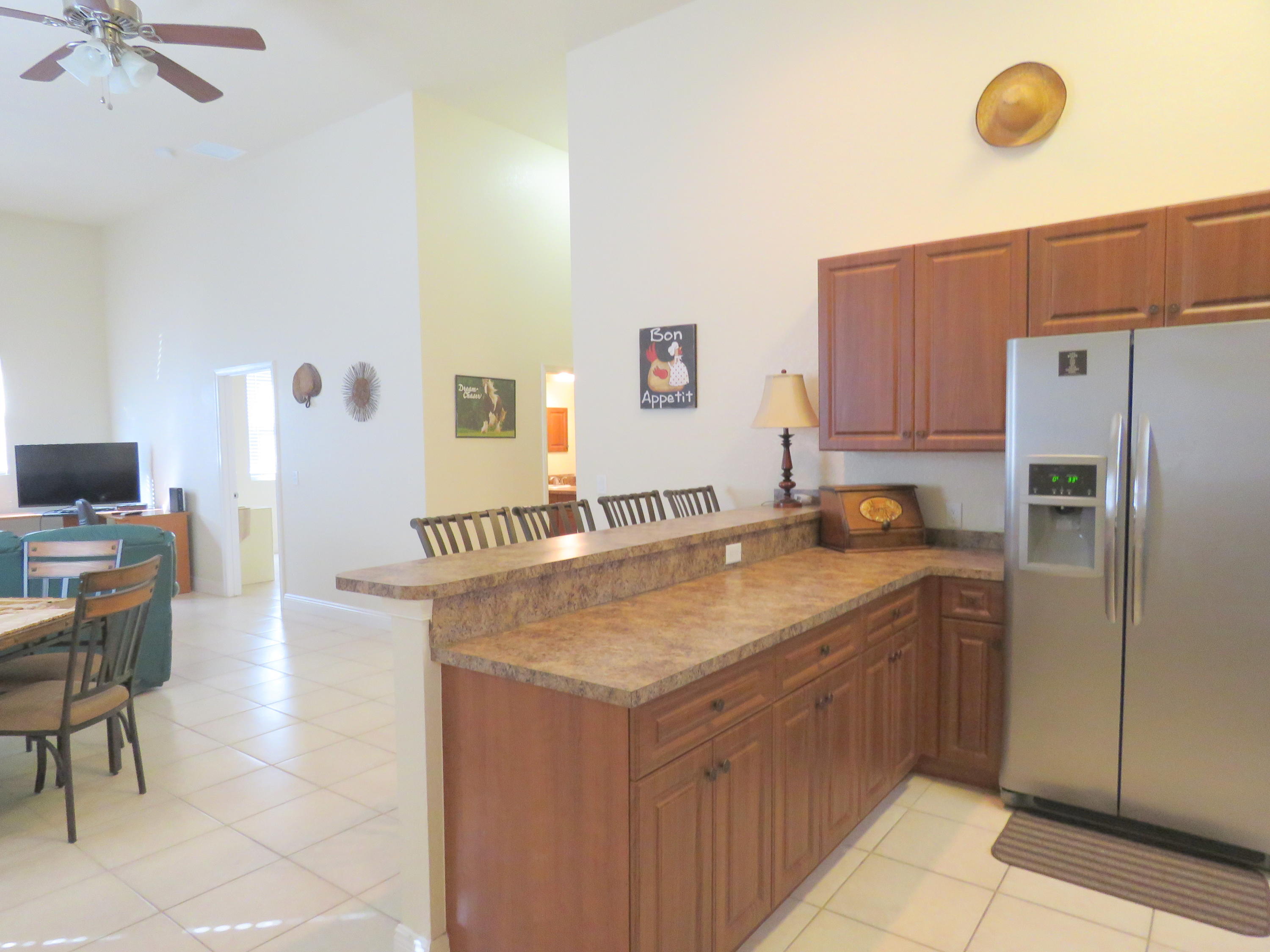 1059 E Road Loxahatchee, FL 33470 - Photo 59 of 82 a kitchen with a sink refrigerator and dining table