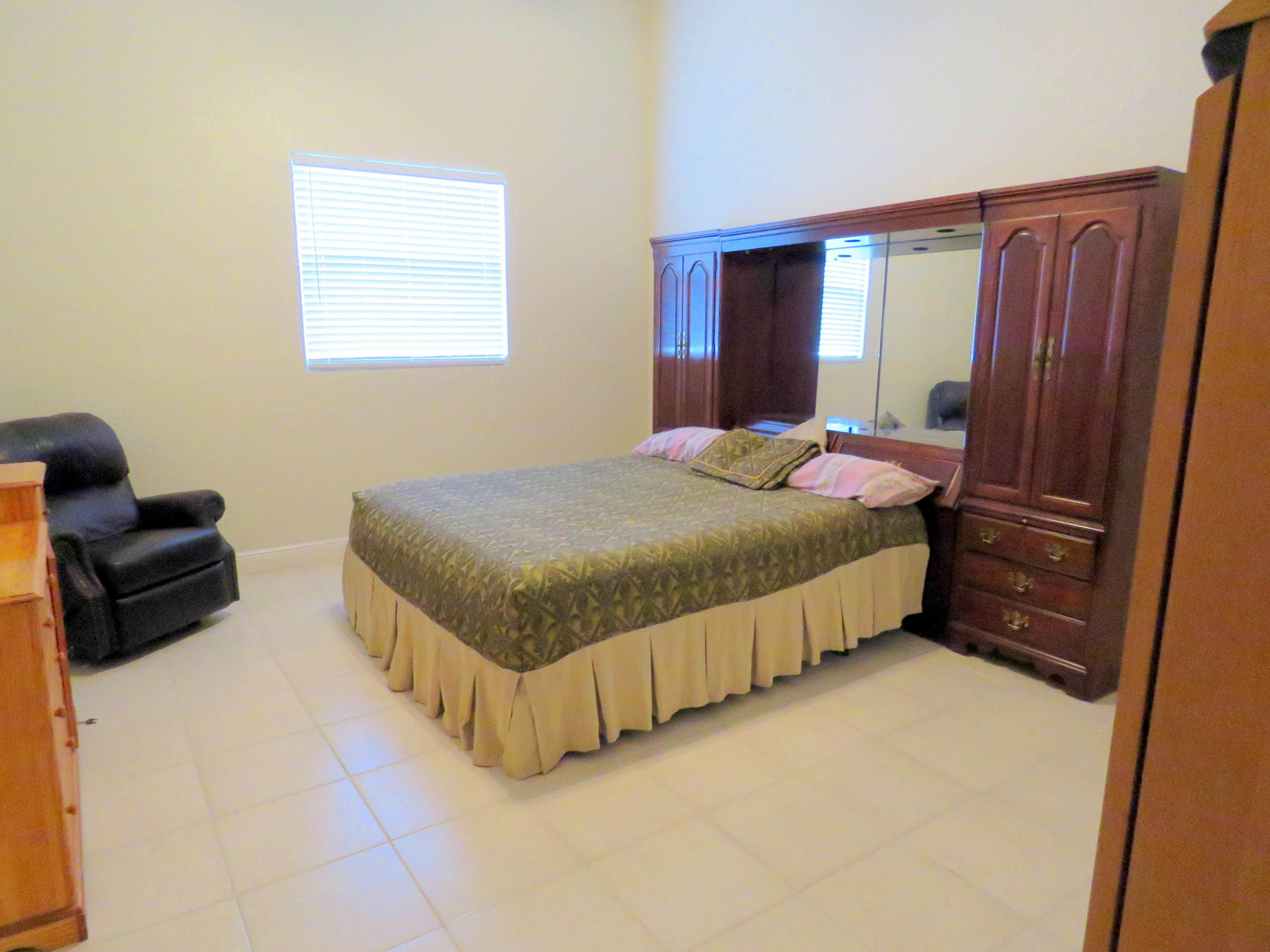 1059 E Road Loxahatchee, FL 33470 - Photo 61 of 82 a bedroom with a bed and a couch