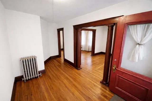 a view of front door with wooden floor and stairs