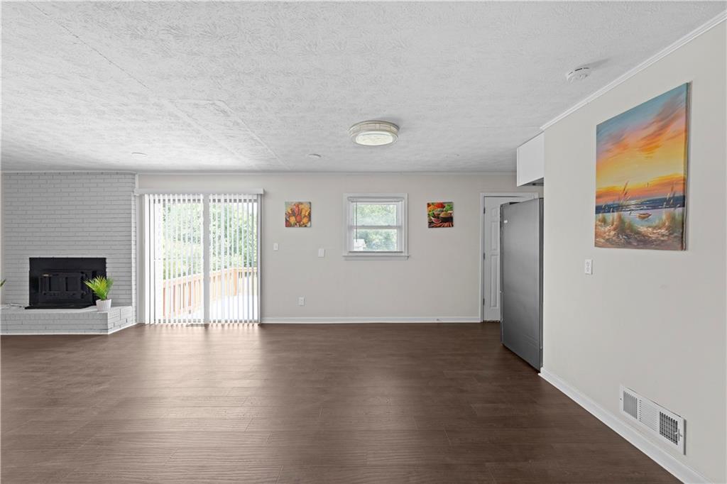 5245 Stonewall Tell Road Atlanta, GA 30349 - Photo 8 of 15 a view of an empty room with wooden floor and a window