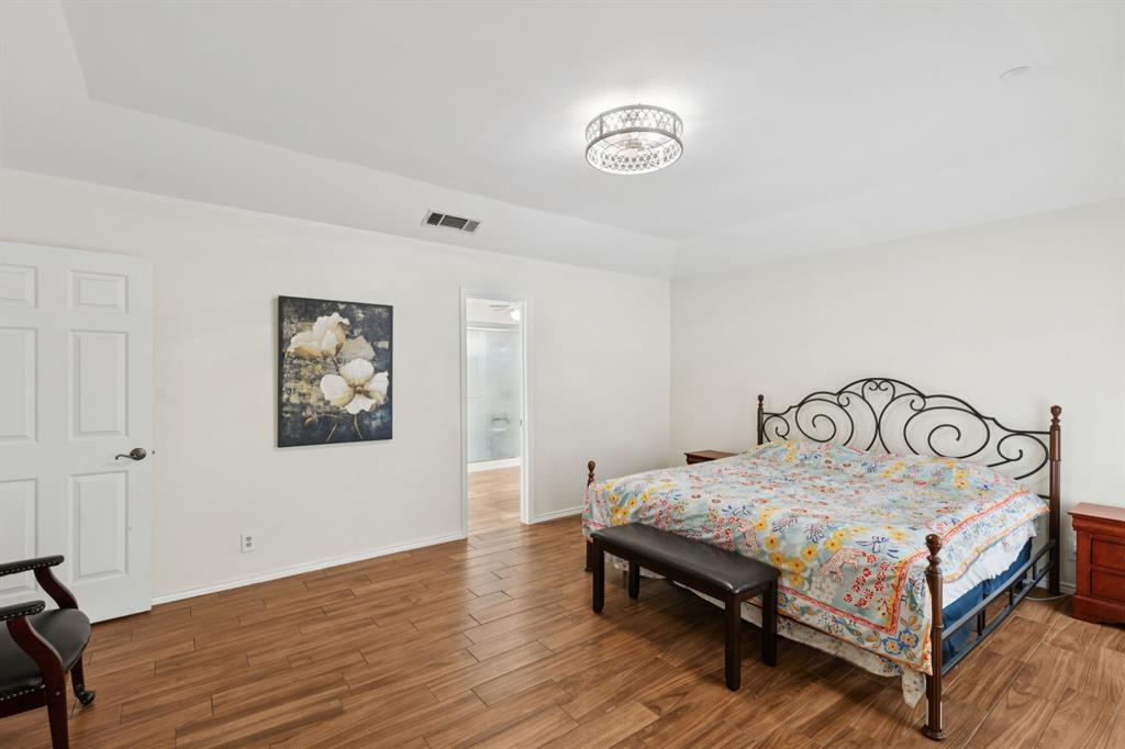 231 Rancho Vista Drive Double Oak, TX 75077 - Photo 15 of 26 a bedroom with a bed and a table