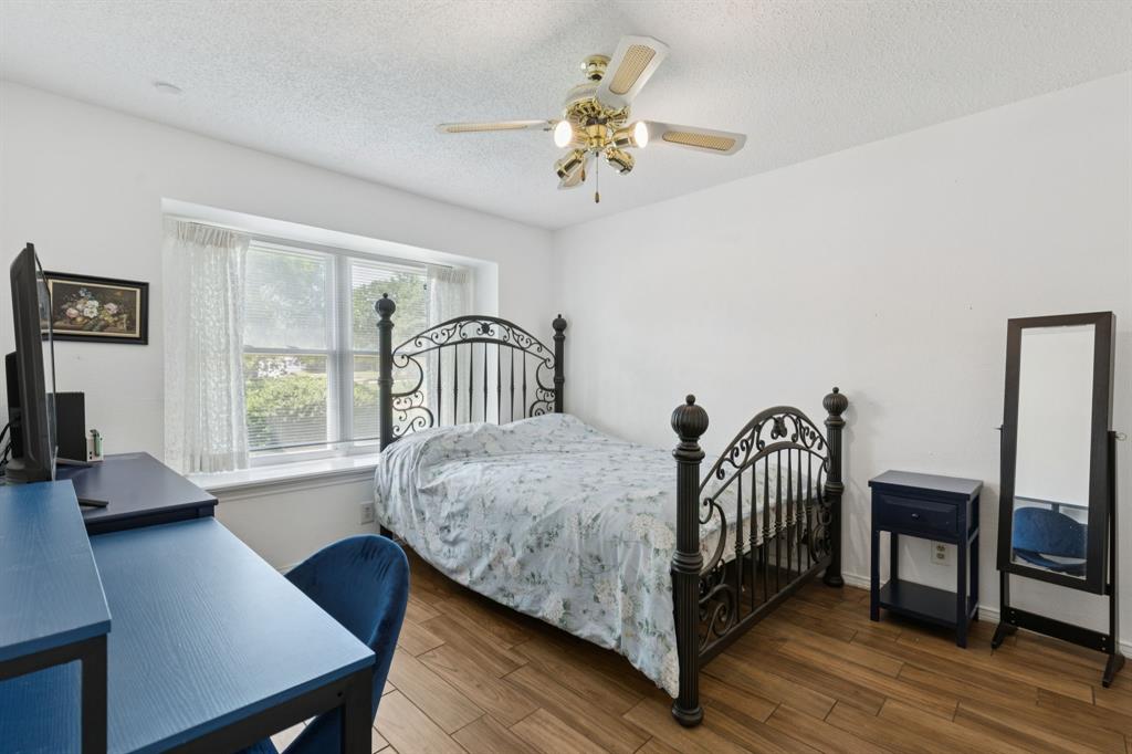 231 Rancho Vista Drive Double Oak, TX 75077 - Photo 20 of 26 a bedroom with a bed a chandelier with a dresser