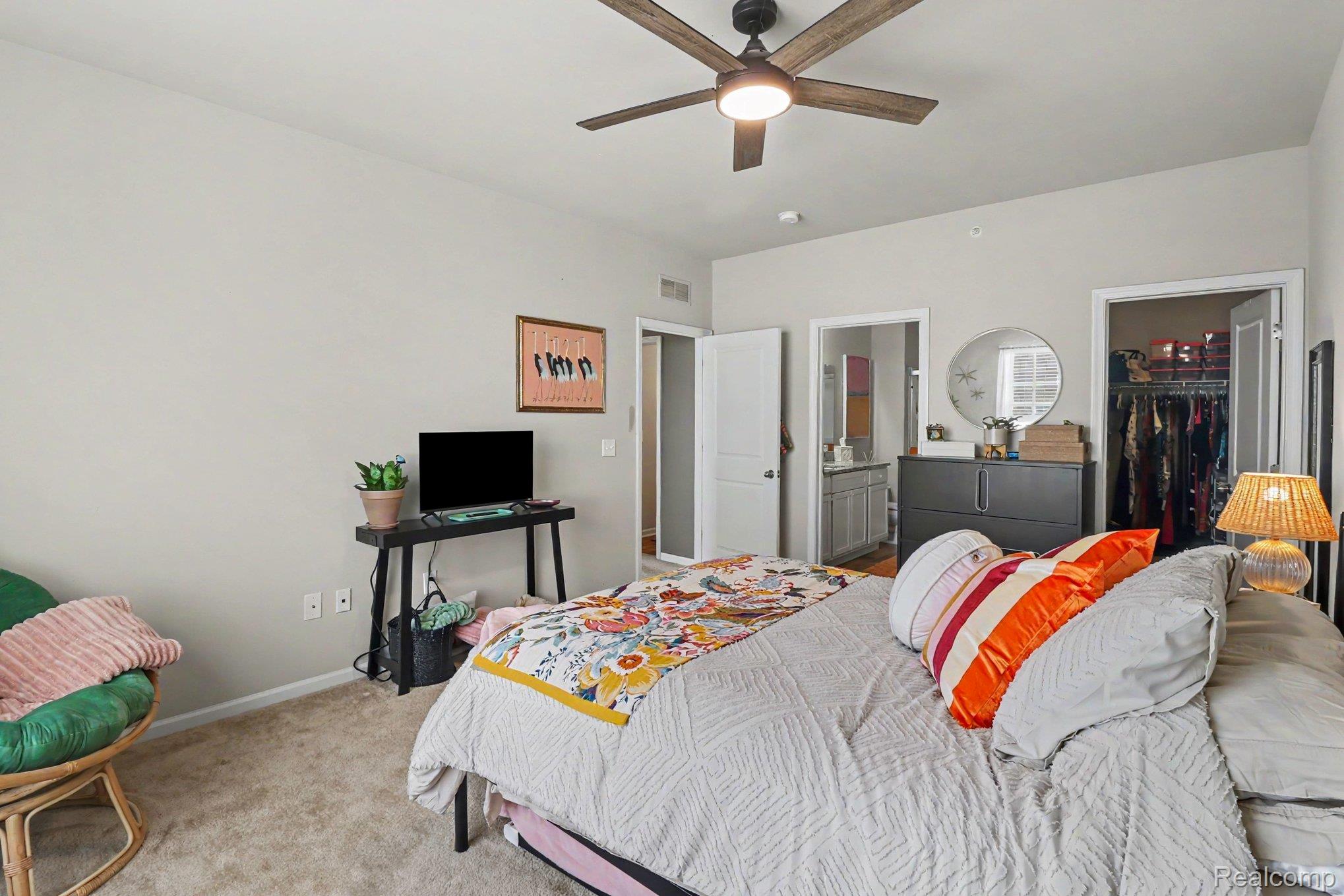 9864 Ridge Run Street Howell, MI 48855 - Photo 16 of 23 Bedroom featuring carpet, a walk in closet, ceiling fan, and ensuite bathroom