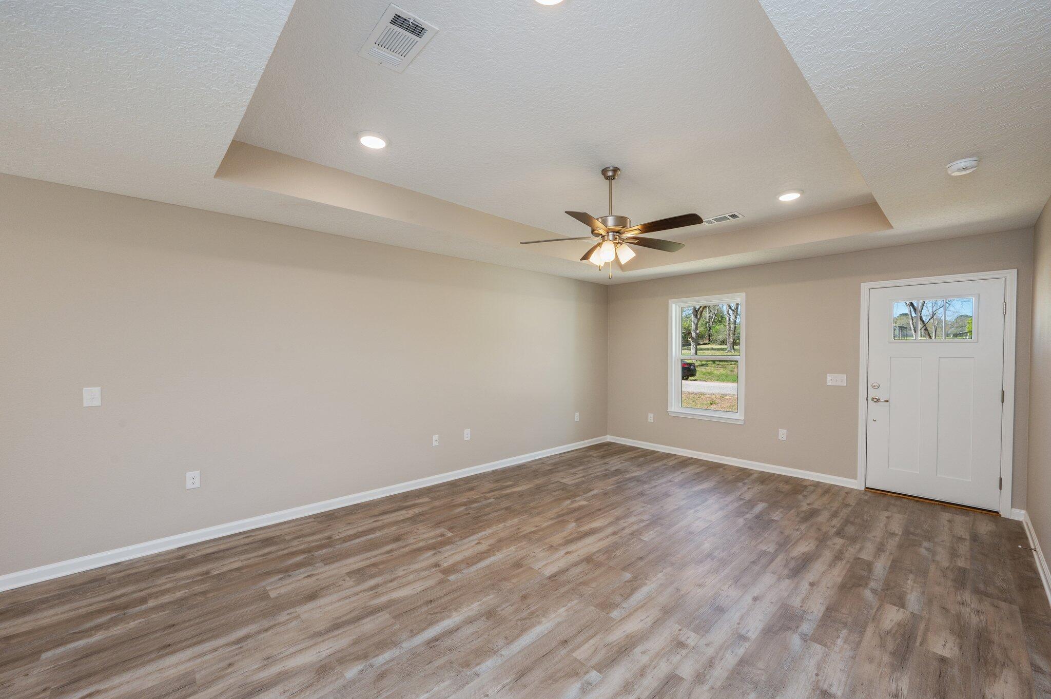 8095 3rd Street Laurel Hill, FL 32567 - Photo 6 of 30 wooden floor in an empty room with a window