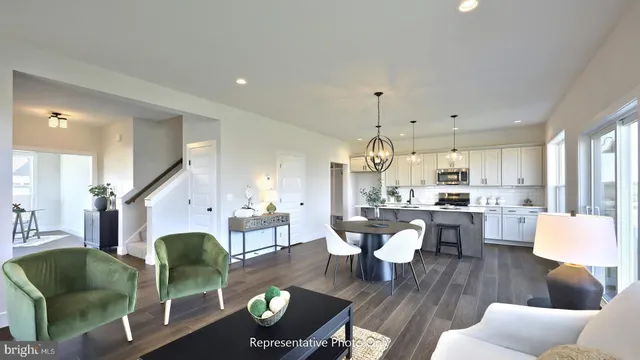 a living room with furniture kitchen view and a chandelier