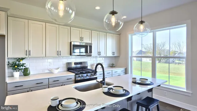 a kitchen with sink a microwave and cabinets