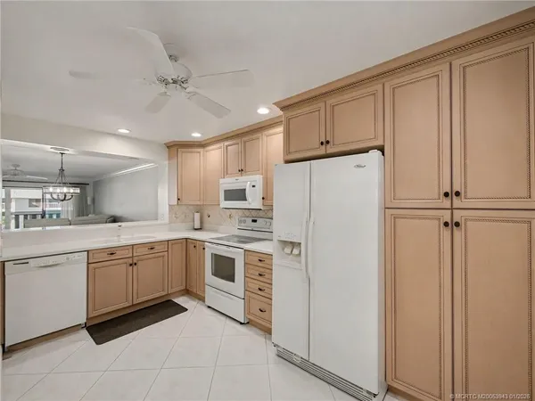 a kitchen with white cabinets and white appliances