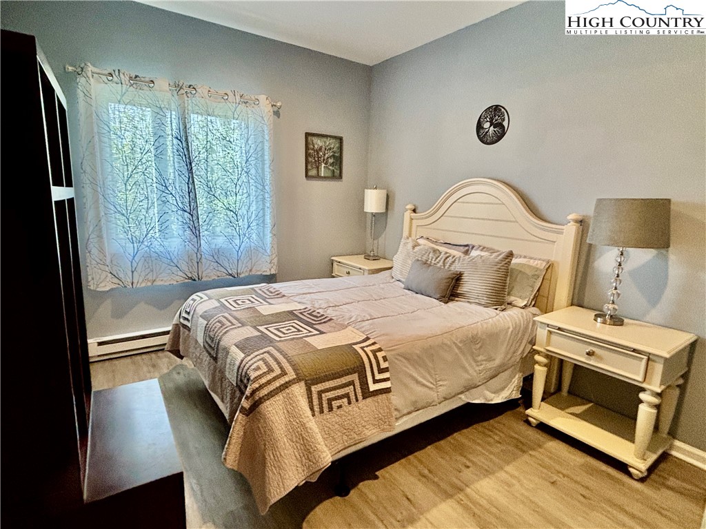 555 Glenview Road Newland, NC 28657 - Photo 32 of 49 a bedroom with a bed lamp and a large window