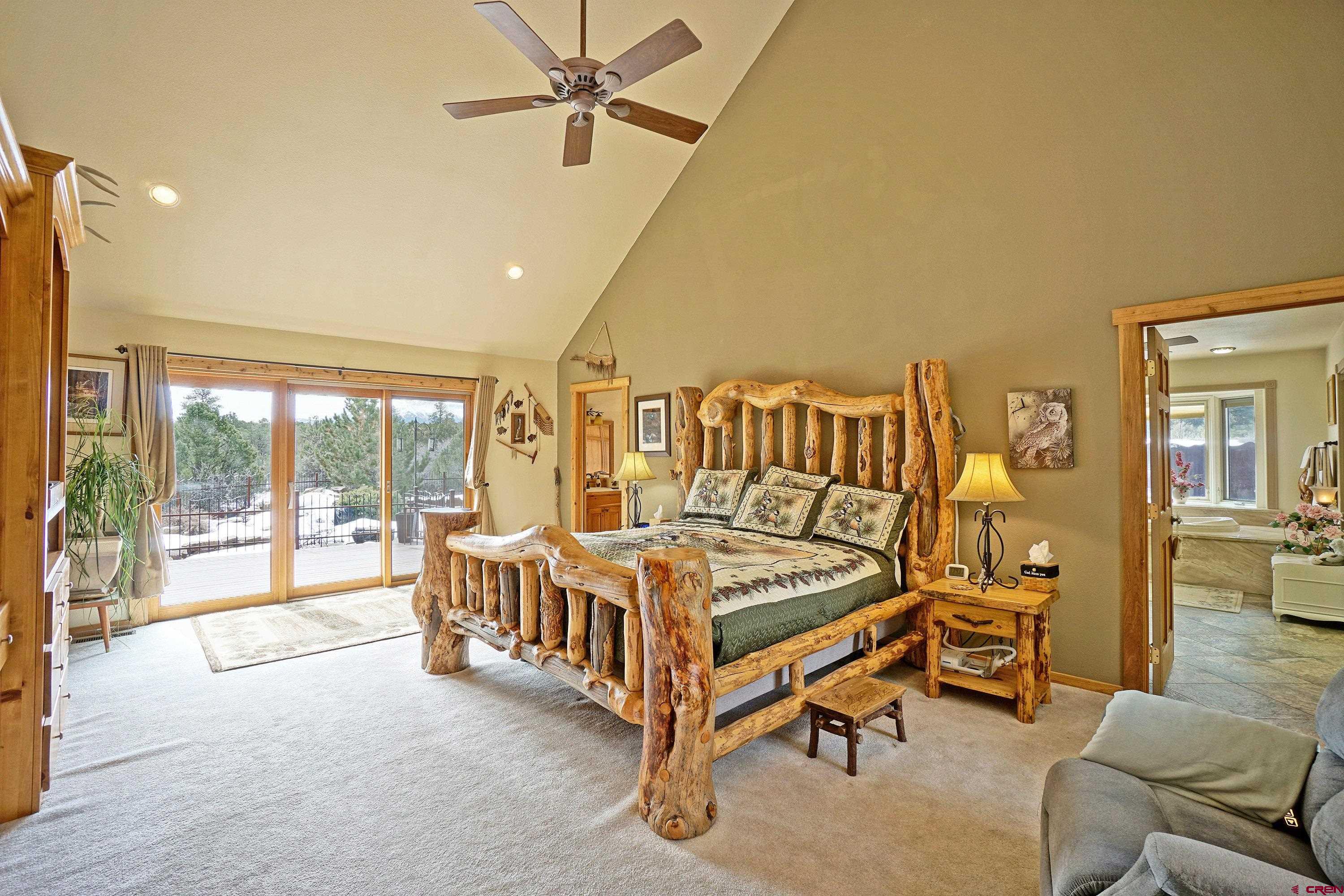 221 Waterview Lane Ridgway, CO 81432 - Photo 15 of 43 a spacious bedroom with a bed and a chandelier