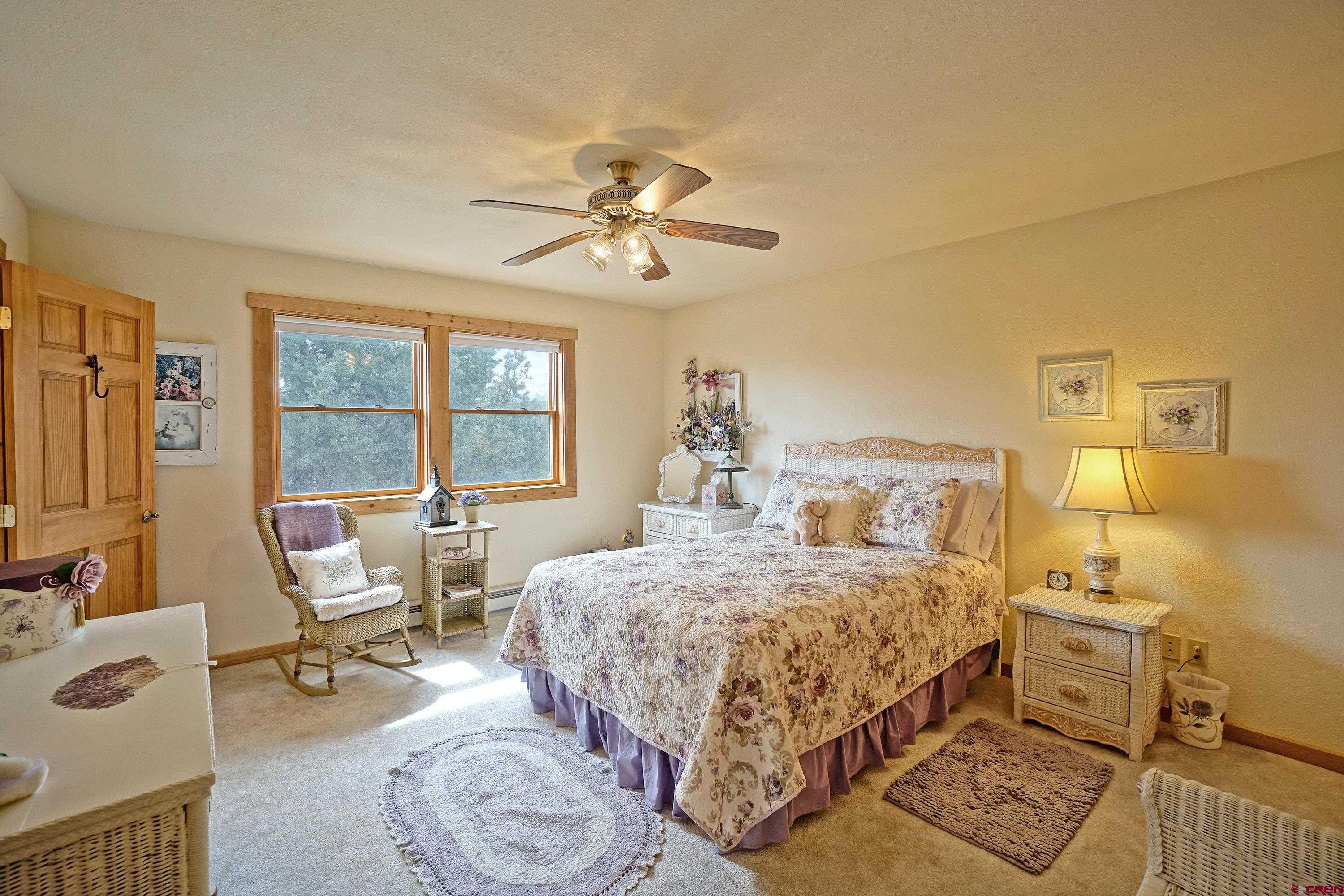 221 Waterview Lane Ridgway, CO 81432 - Photo 20 of 43 a bedroom with a bed a table and chair with the potted plant