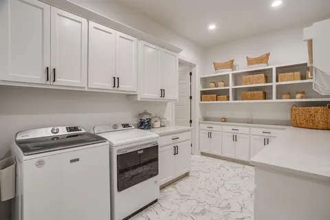 a kitchen with granite countertop white cabinets and white appliances