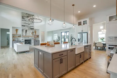 a kitchen with counter top space and living room view