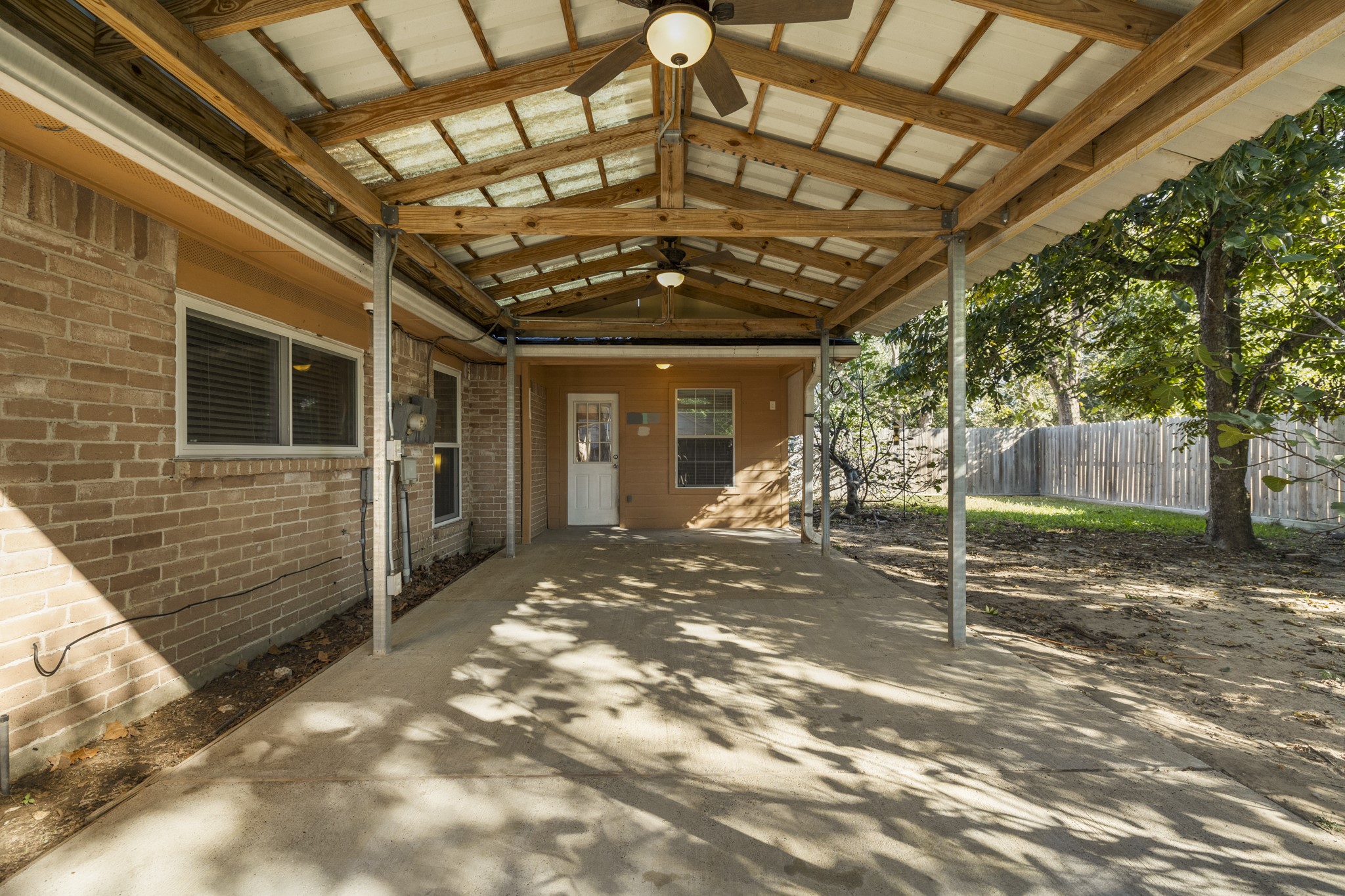 23826 Lestergate Drive Spring, TX 77373 - Photo 32 of 45 Looking back toward the home, this angle shows just how much usable space the covered patio adds. With room to spread out beneath the roofline, it’s easy to picture a dining table, grill setup, and lounge seating all working together here. The backyard remains open just beyond, giving this outdoor space a natural connection to the rest of the yard and plenty of potential for everyday relaxing or weekend get-togethers.