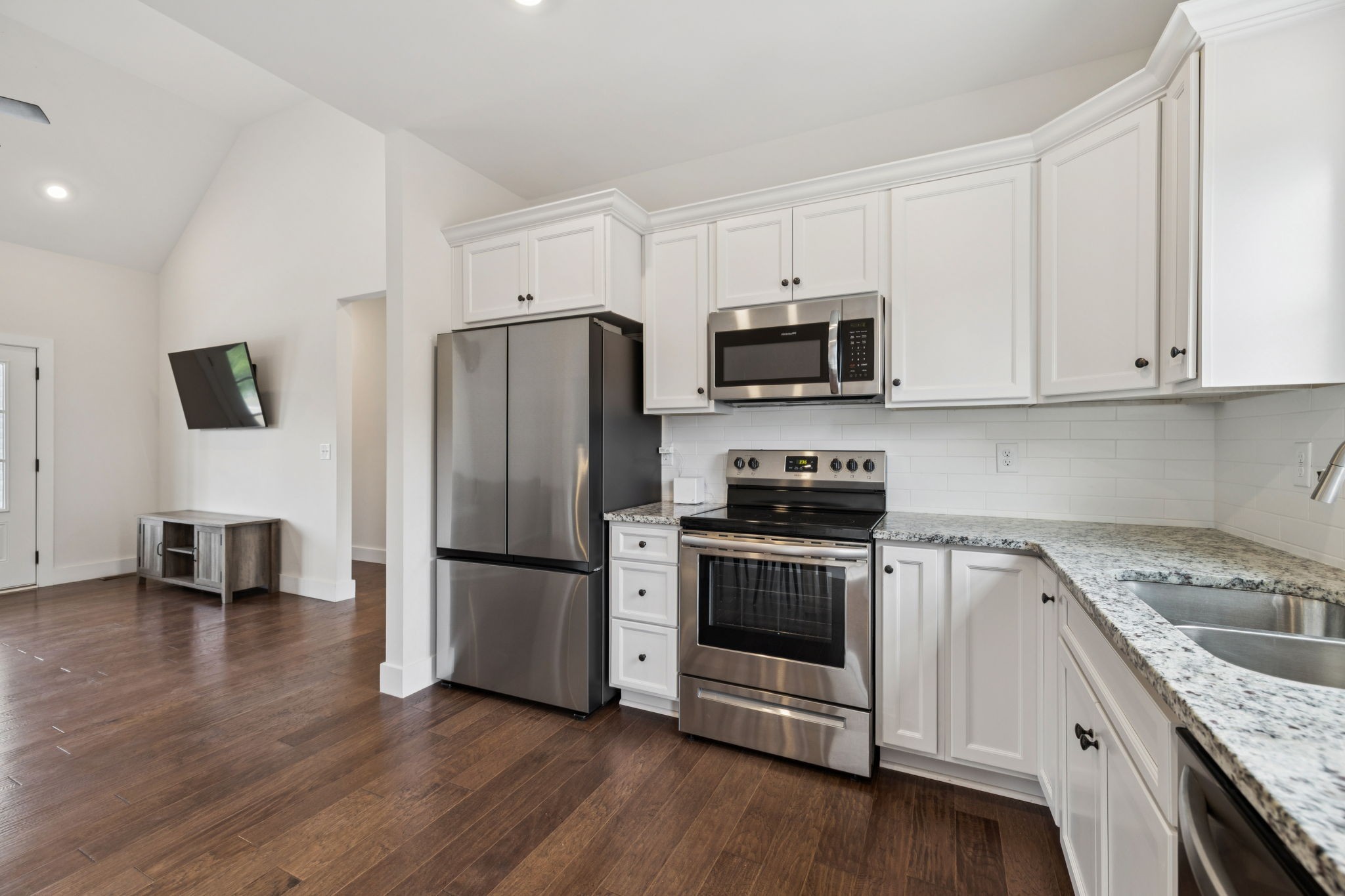 1220 Columbia Road Charlotte, TN 37036 - Photo 9 of 41 a kitchen with granite countertop a refrigerator a stove a sink and white cabinets