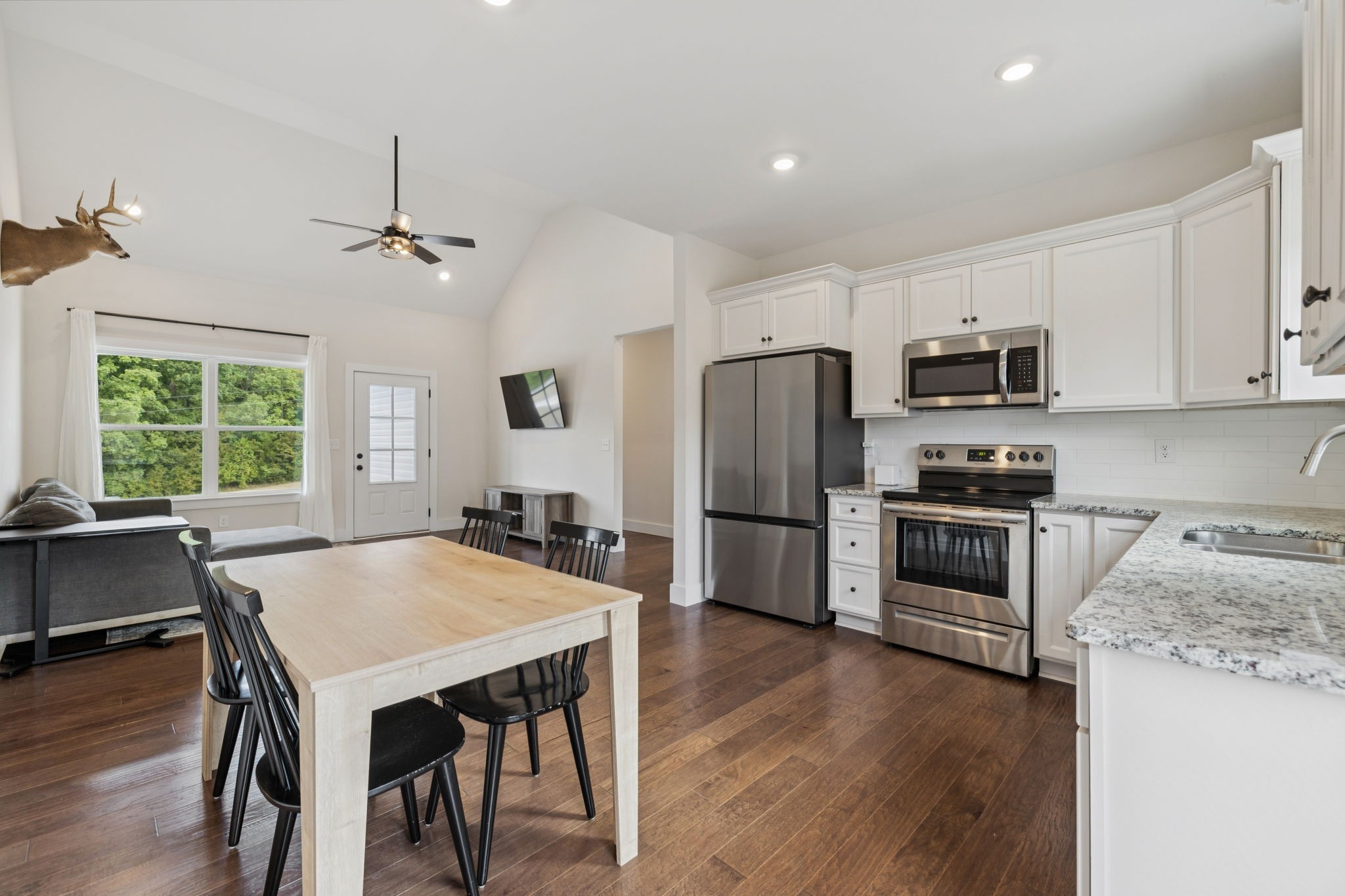 1220 Columbia Road Charlotte, TN 37036 - Photo 10 of 41 a kitchen with refrigerator wooden floor dining table and chairs