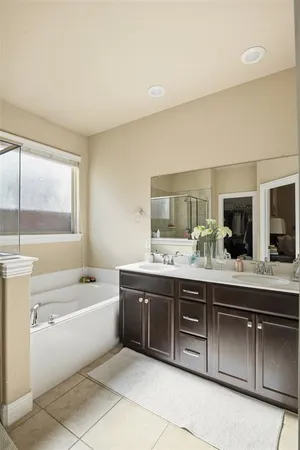 a spacious bathroom with a tub sink and mirror