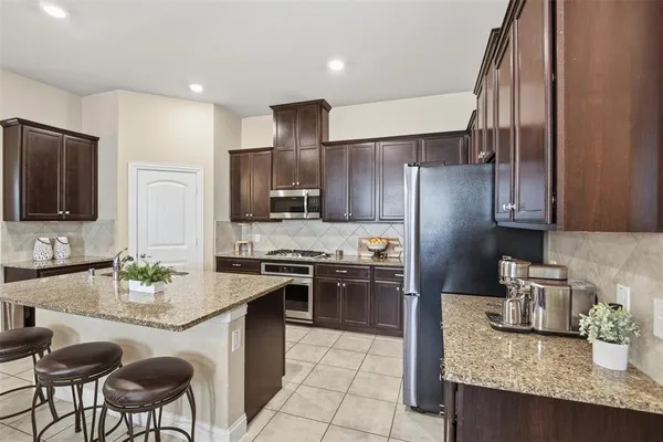 a kitchen with granite countertop a sink stainless steel appliances and cabinets
