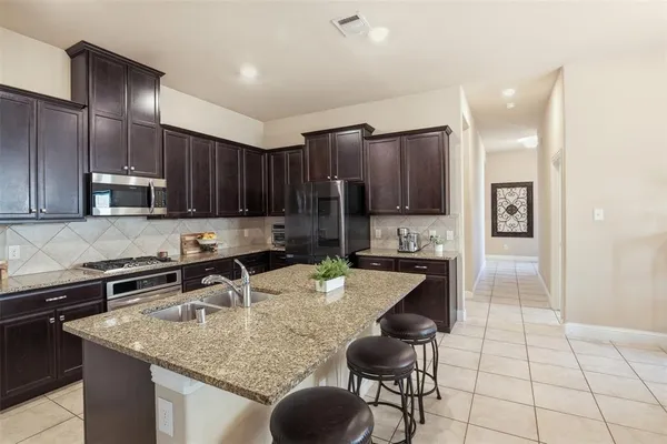 a kitchen with stainless steel appliances granite countertop a sink a stove a microwave and cabinets