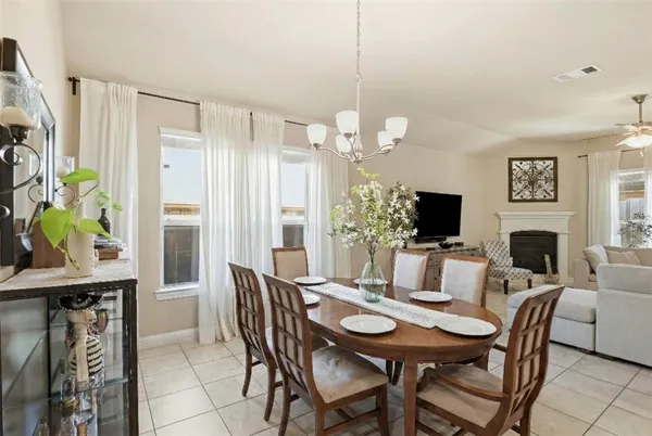 a view of a dining room with furniture a chandelier and wooden floor