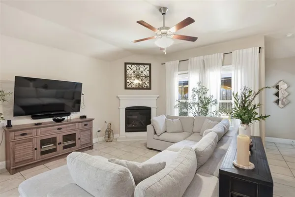 a living room with furniture a flat screen tv and a fireplace