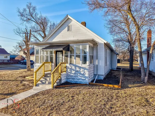 a view of a white house with iron fence next to a road