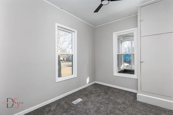 an empty room with windows and closet