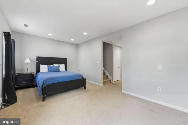 a spacious bedroom with a bed and a lamp