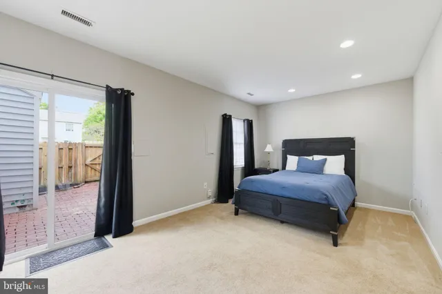 a spacious bedroom with a bed and glass door