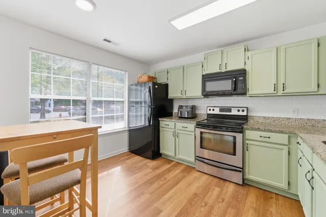 a kitchen with granite countertop a stove a sink and a microwave