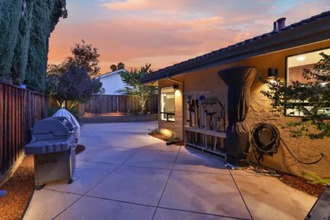 a view of a porch with a hanging chair and a fireplace